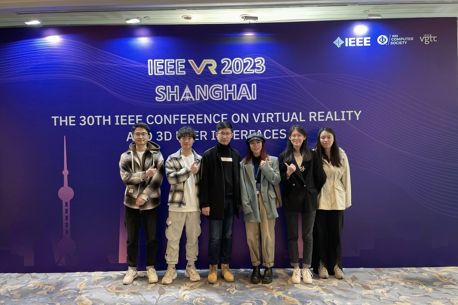 HER Lab members in front of the IEEE VR 2023 conference backdrop in Shanghai.
